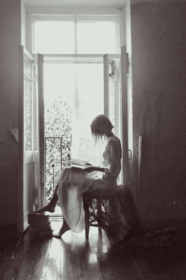 reading in window girl