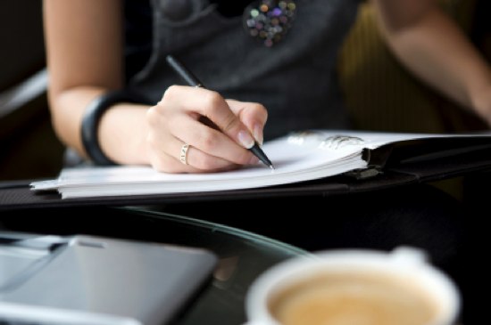 woman writing with coffee