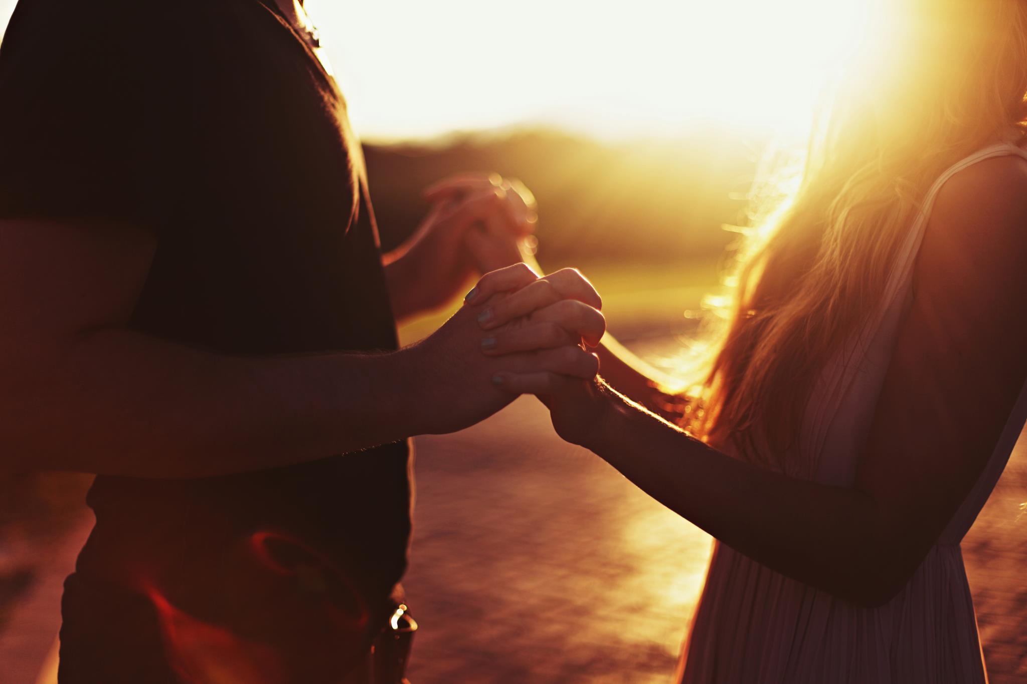couple holding hands in sunshine
